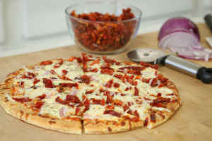 Pizza topped with sun dried tomatoes